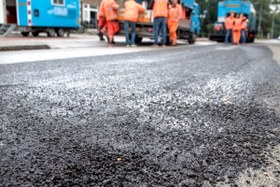 foto van wegdek met op de achtergrond wegwerkers