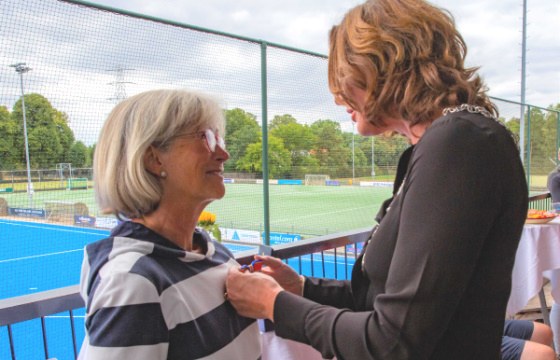 Foto van locoburgemeester Nermina Kundić die de Koninklijke Onderscheiding opspeldt bij Veronique van der Schans-Klessens.