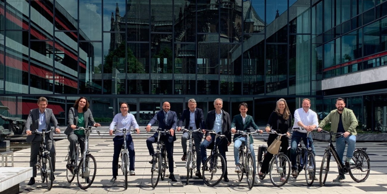 De leden van het nieuwe college op de fiets voor het stadhuis